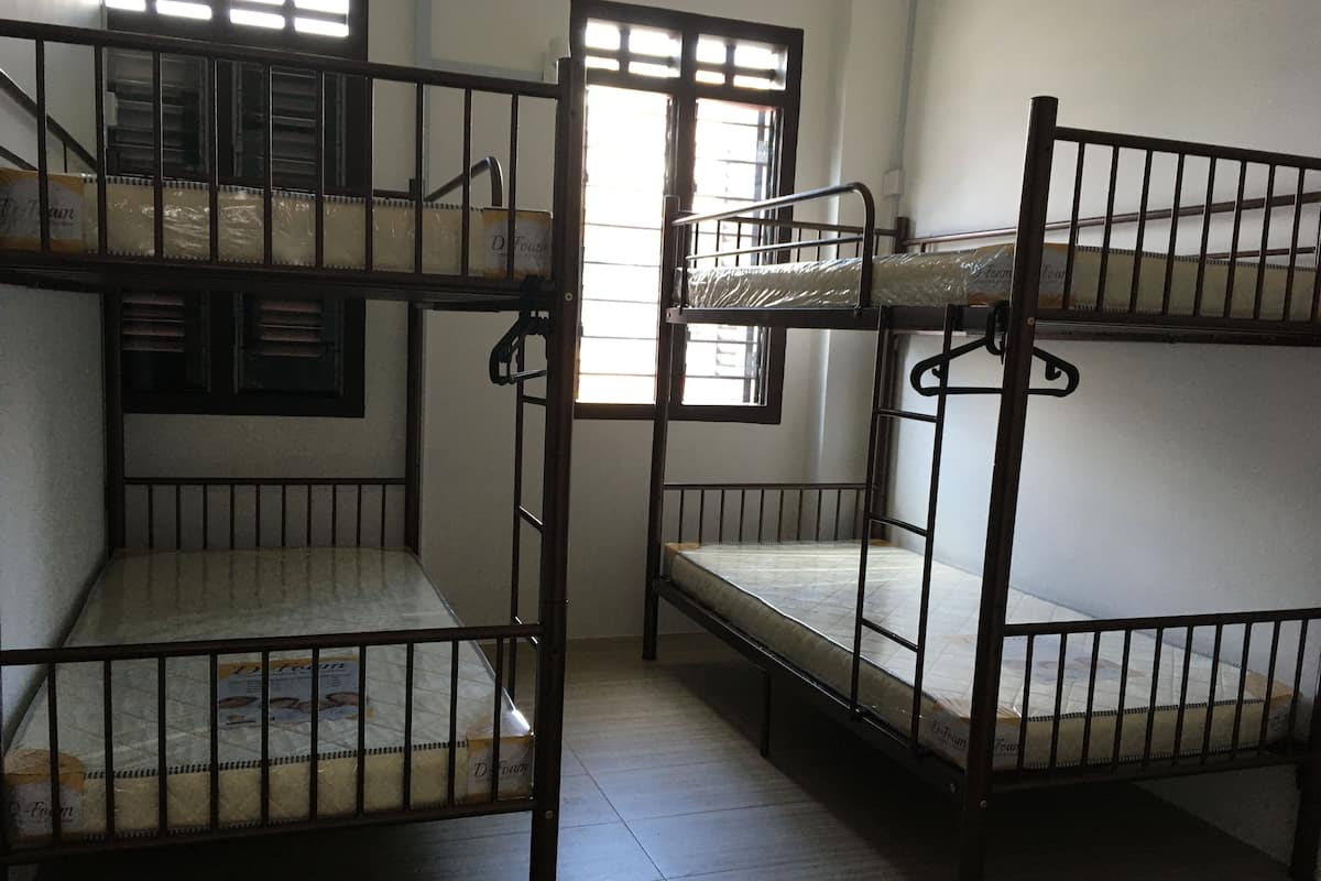 Bunk beds in a dormitory room with a window and a door.