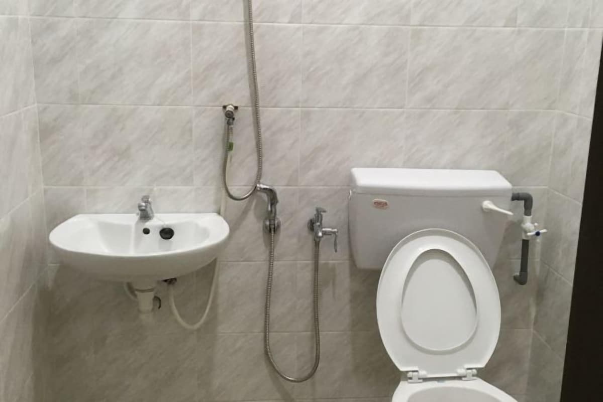 A bathroom with a white sink, toilet, and shower.