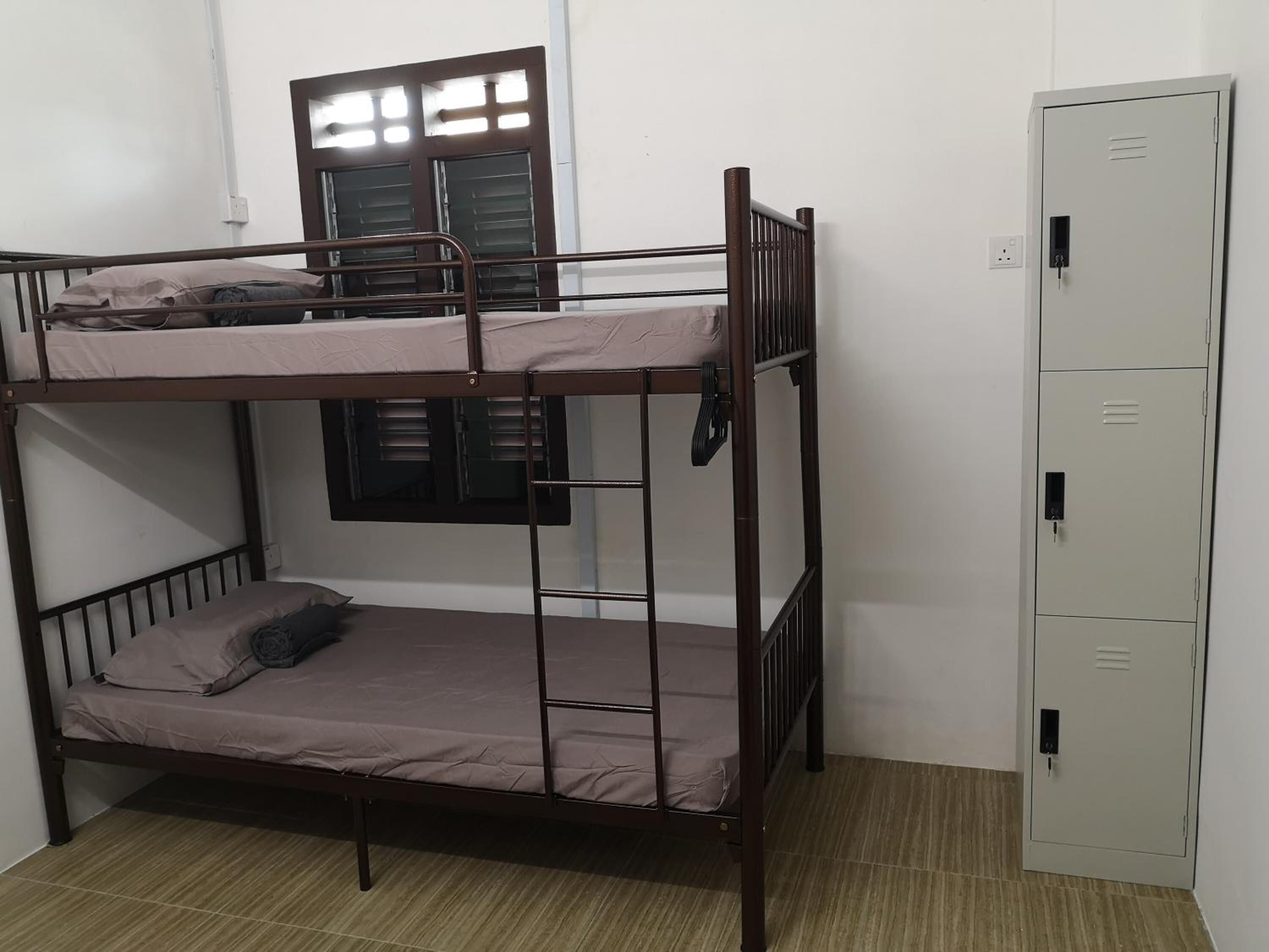 A bunk bed room with a wardrobe and a window with shutters.