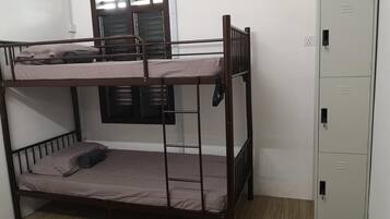 A bunk bed room with a wardrobe and a window with shutters.