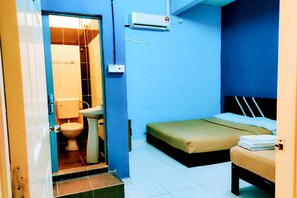 A small, compact room with a bed, a bedside table, a sink, and a toilet. - Q Hotel (Kuala Perlis)