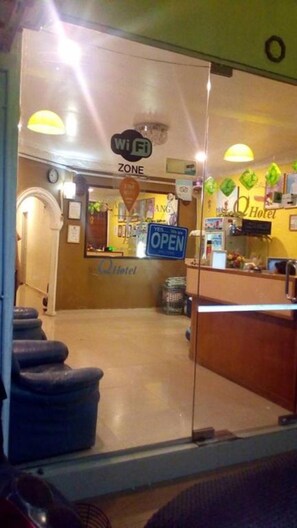A hotel entrance with a Wi-Fi zone sign, a 'Yes, Open' sign, and a visible reception desk. - Q Hotel (Kuala Perlis)