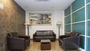 A lobby with a brown leather sofa, two armchairs, a coffee table, and a painting on the wall. - Kepong Hotel (Kuala Lumpur)