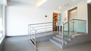 A modern interior with a staircase, metal handrails, and a glass railing. - Kepong Hotel (Kuala Lumpur)