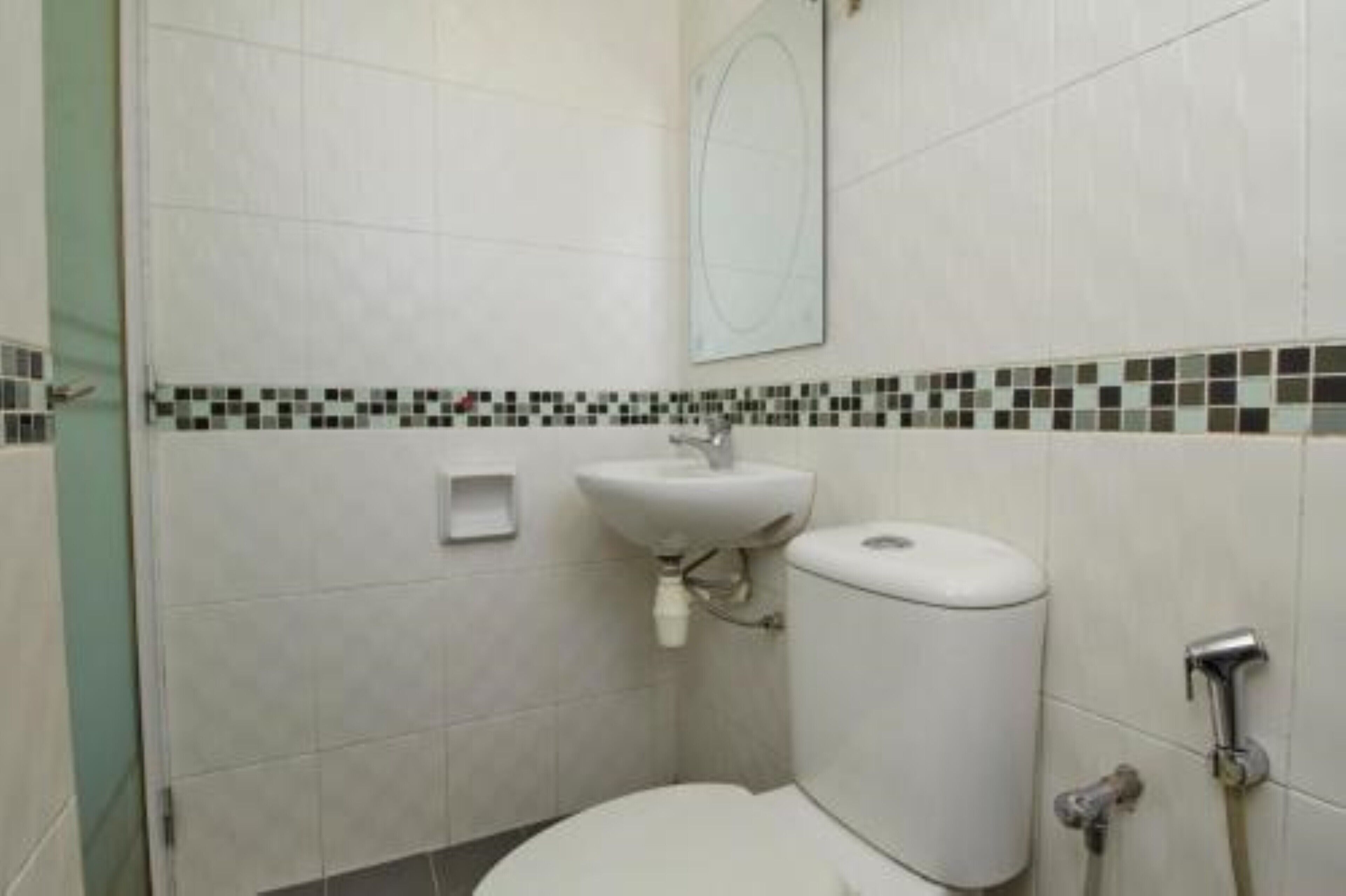 A small, clean bathroom with a toilet, sink, and shower.