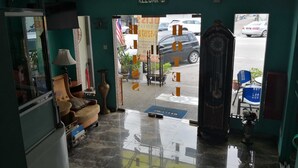 A hotel lobby with a tiled floor, a reception desk, a sofa, and a large window overlooking the street. - Hotel Bliss Johor Bahru Skudai (Johor Bahru)
