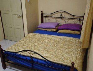 A single bed with a patterned bedspread, two pillows, and a metal headboard. - Hasienda Homestay Bayan Lepas (George Town)