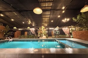 An indoor swimming pool with a tiled floor, surrounded by brick walls, and overhead lighting fixtures. - Petak Padin Cottage by The Pool, Kepala Batas Penang (Kepala Batas)