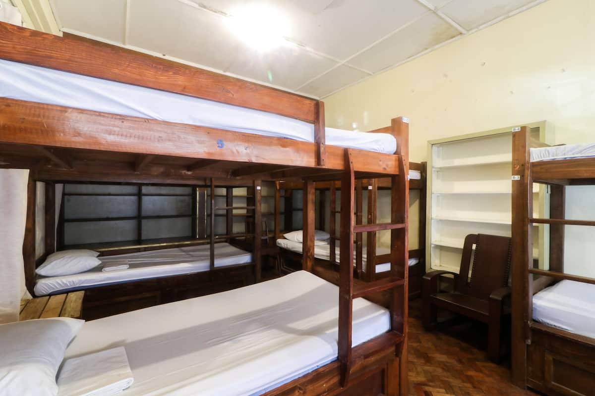 Quarto com beliches de madeira e uma cadeira.