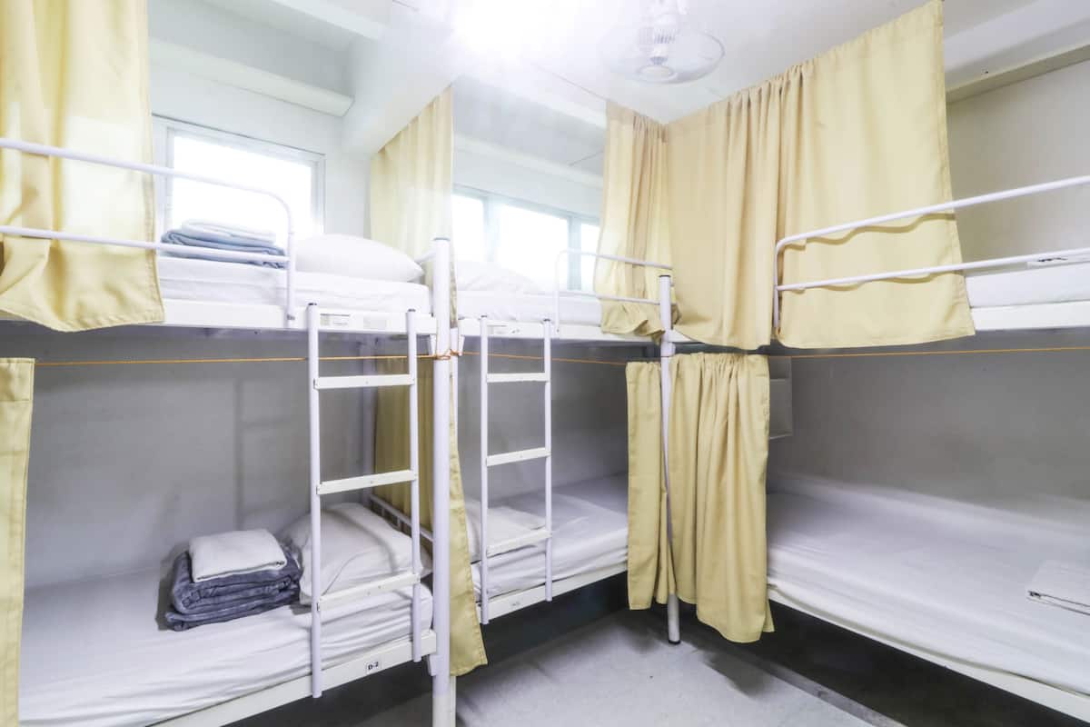 Habitación con literas, dos camas, cada una con una escalera y una ventana.