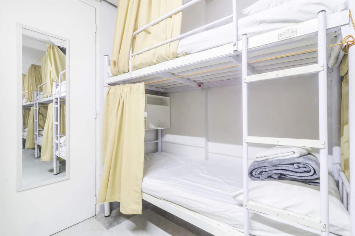 Habitación con literas, espejo y cortinas.