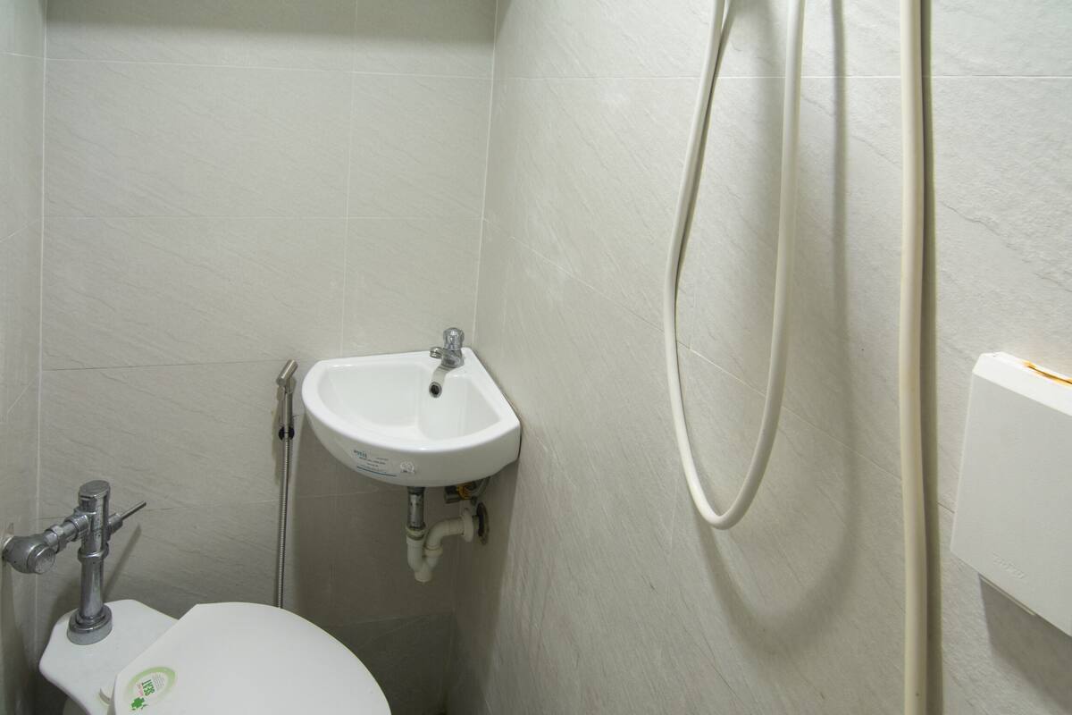 Un baño pequeño con inodoro, lavamanos y ducha.