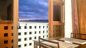 A balcony with a view of a cityscape at dusk.