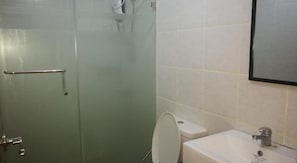 Ein Badezimmer mit Duschkabine, Toilette und Waschbecken.