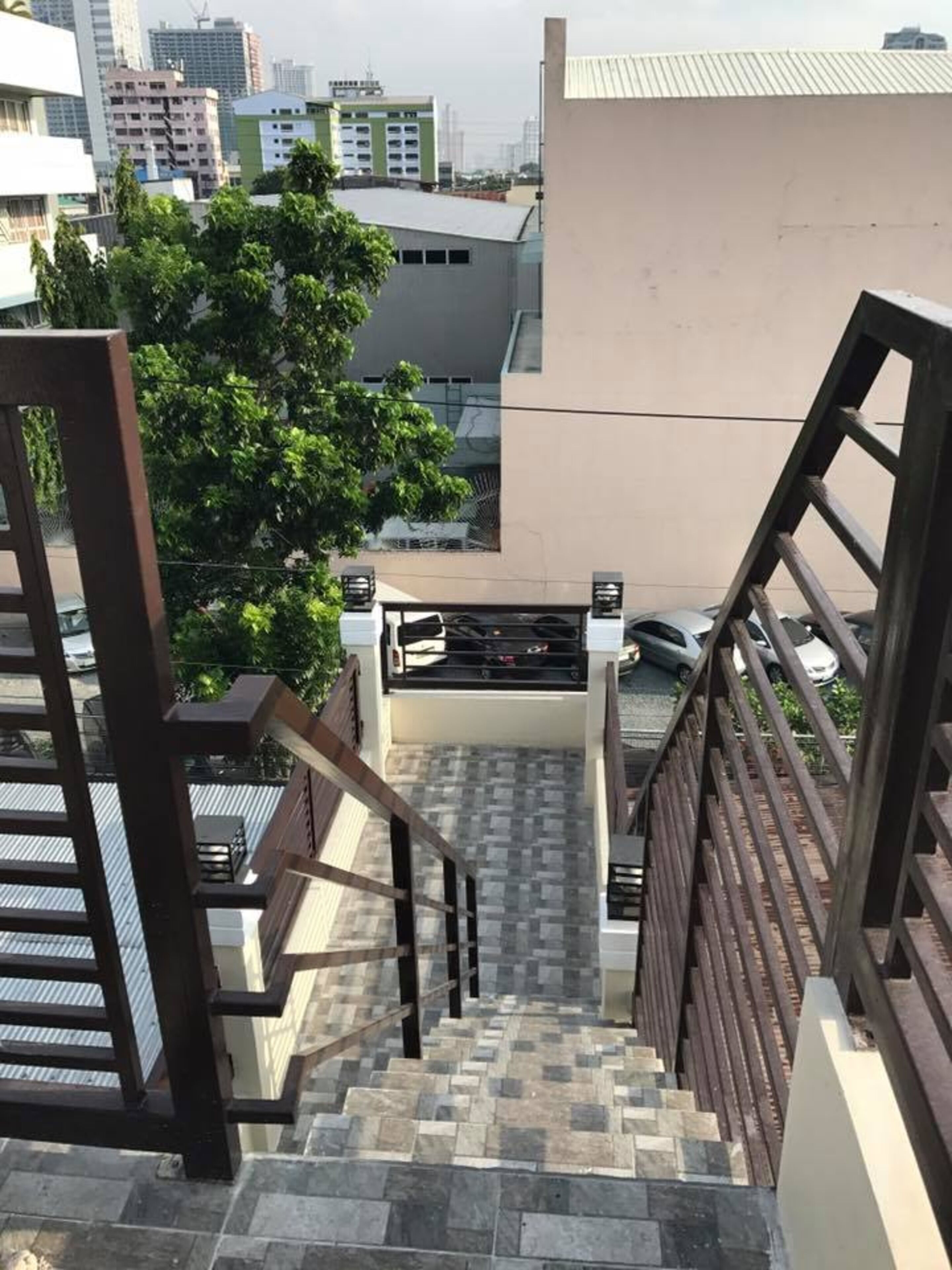 A staircase with a metal railing leading to a rooftop area.
