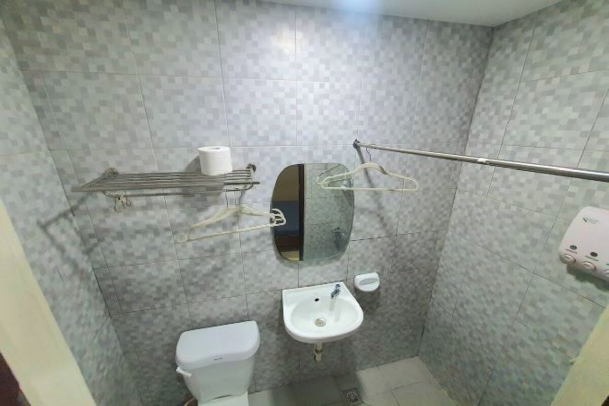Une petite salle de bain avec des toilettes, un lavabo et un miroir.