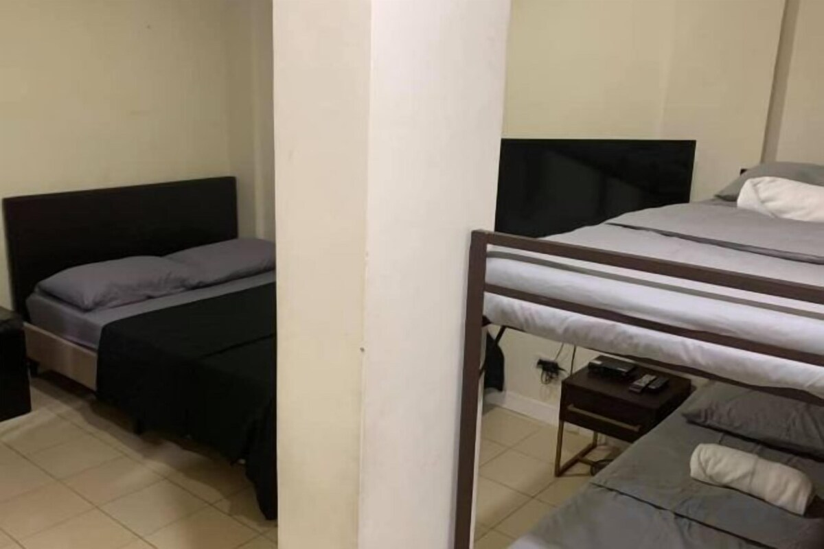 A room with two beds, a television, and a small table.