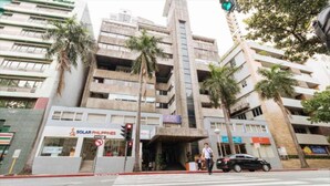 A multi-story building with a modern architectural design, featuring a prominent entrance with a staircase. - Rd Suites Greenbelt (Makati)
