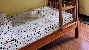 A bunk bed with a wooden frame and a polka dot bedspread. - Jhunlyn Rooms for Rent Tagaytay (Tagaytay)