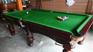 A pool table with a green felt surface, surrounded by wooden legs and a dark wood frame. - Center Home City (Chiang Mai)