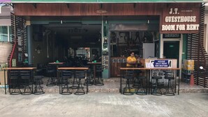 A guesthouse with a wooden facade, a bar area, and a sign advertising room for rent. - JT Guesthouse (Kamala)