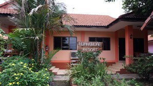 A building with a sign reading "Euangnuae Resort." It has a tiled roof, a staircase leading to the entrance, and is surrounded by various plants and flowers. - Euangnuae Resort (Mae Rim)
