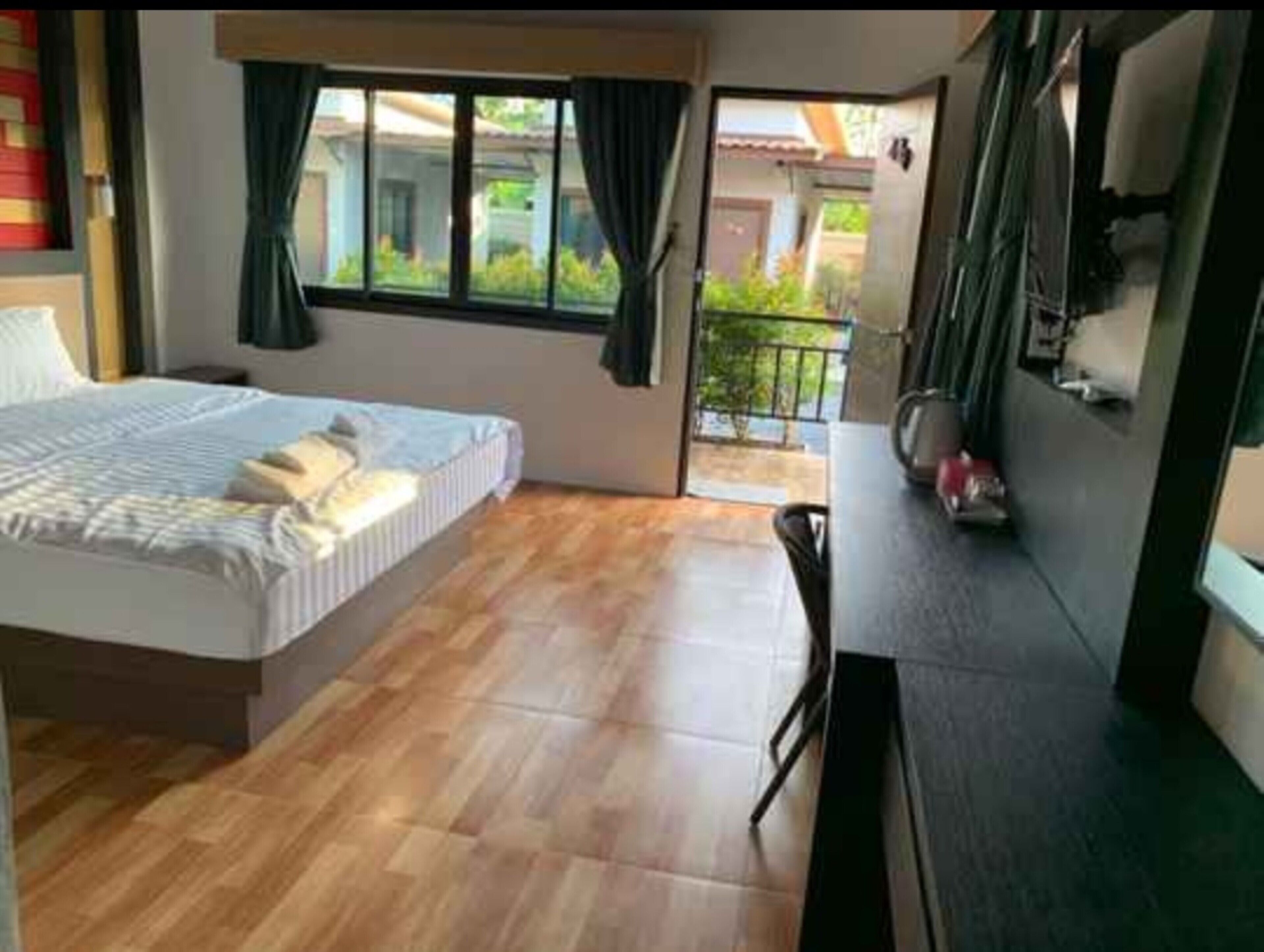 Un dormitorio con cama, escritorio y vistas al exterior.