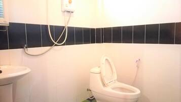 Un baño con inodoro, lavabo y ducha.