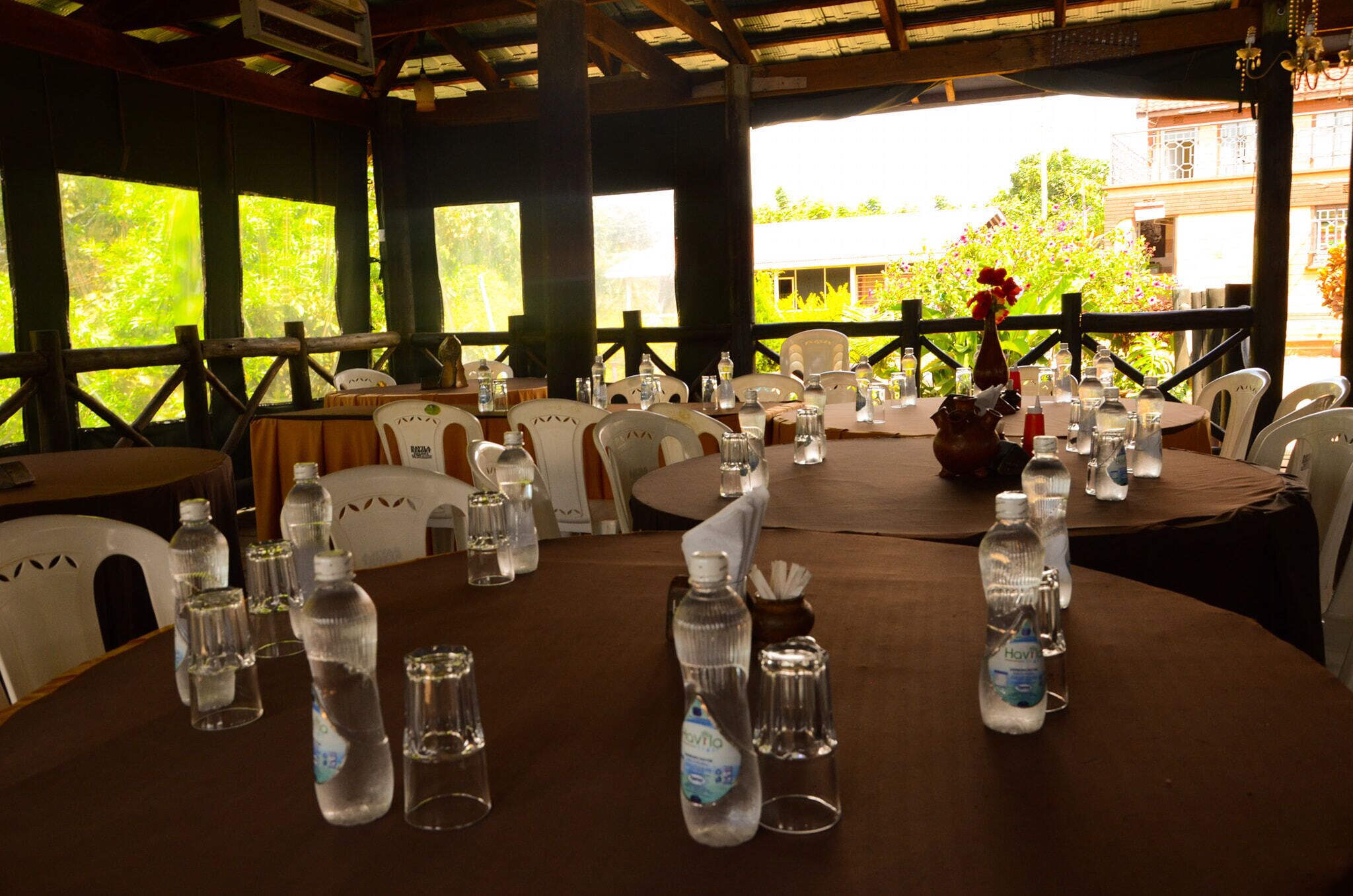A dining area with tables set for a meal, each with water bottles and glasses.