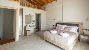 Une chambre avec un plafond en bois, un grand lit avec des oreillers, une table de chevet et un miroir.