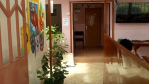 A hallway with a potted plant, a painting on the wall, and a door labeled "KITCHEN". - Marra Hill Hotel (Nakuru)