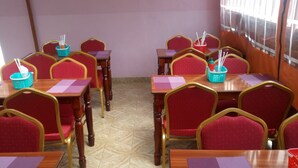 A classroom with wooden desks and red chairs, arranged in rows. - Marra Hill Hotel (Nakuru)