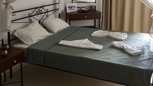 Un lit à baldaquin avec des rideaux blancs, une table de chevet avec une lampe, un miroir et un petit bureau avec une chaise.