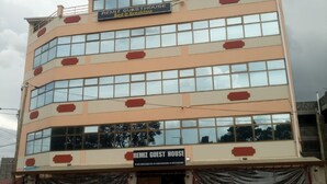 A multi-story building with a sign indicating it is a guest house offering bed and breakfast. - Remiz Guest House (Nakuru)