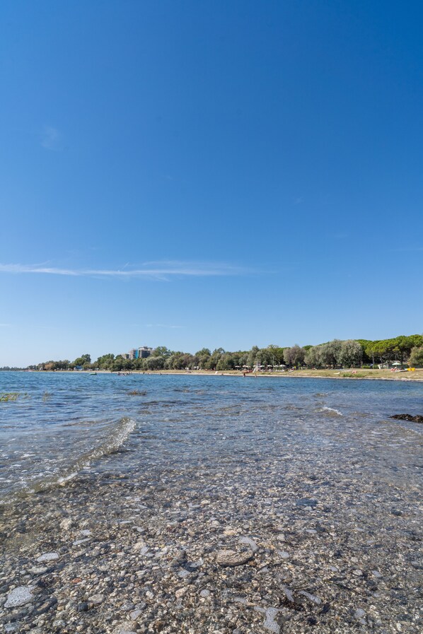 Privat strand, solsenger, parasoller og strandbar