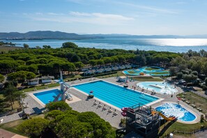An aerial view of a resort with a large swimming pool, a water slide, and a view of the sea. - Club Del Sole Marina Julia Family Collection (Monfalcone)