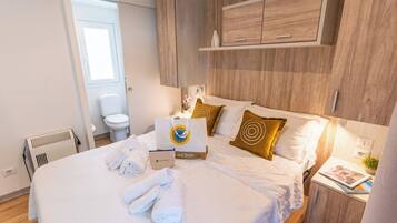Ein Hotelzimmer mit Bett, Nachttisch, Schrank, Toilette und Fenster.