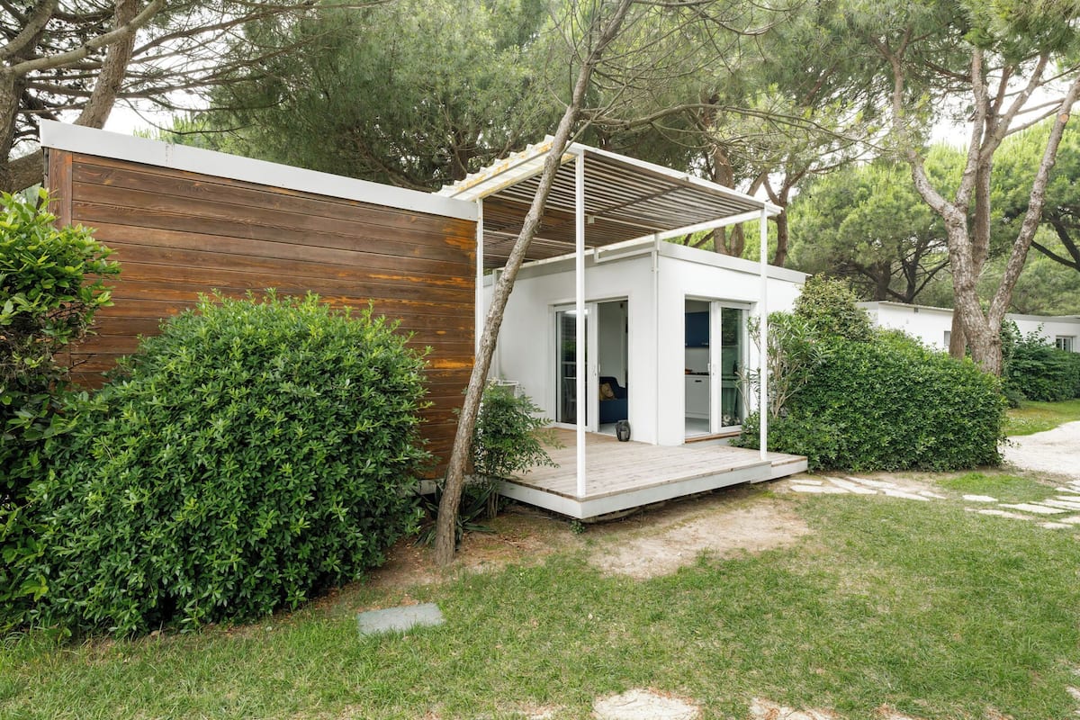 Une maison moderne avec une façade en bois, un porche abrité et un jardin bien entretenu.