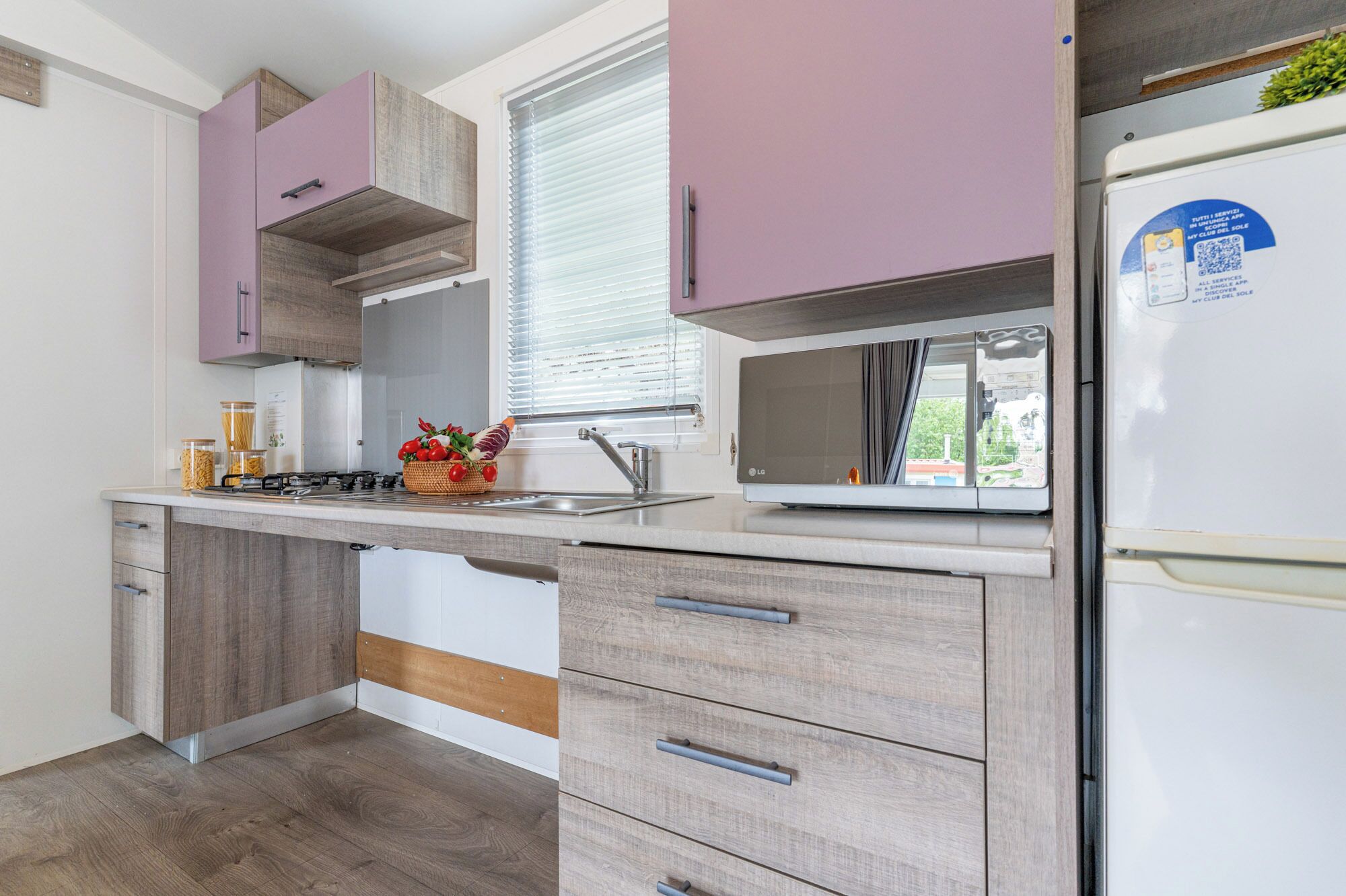 A modern kitchen with wooden cabinets, a built-in stove, and a refrigerator.