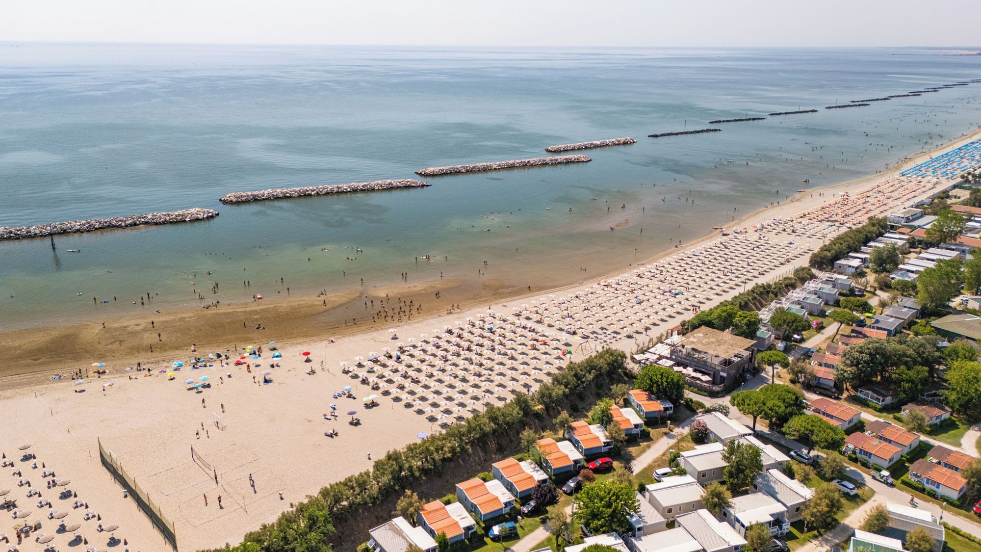 Privatstrand, Liegestühle, Sonnenschirme, Volleyball