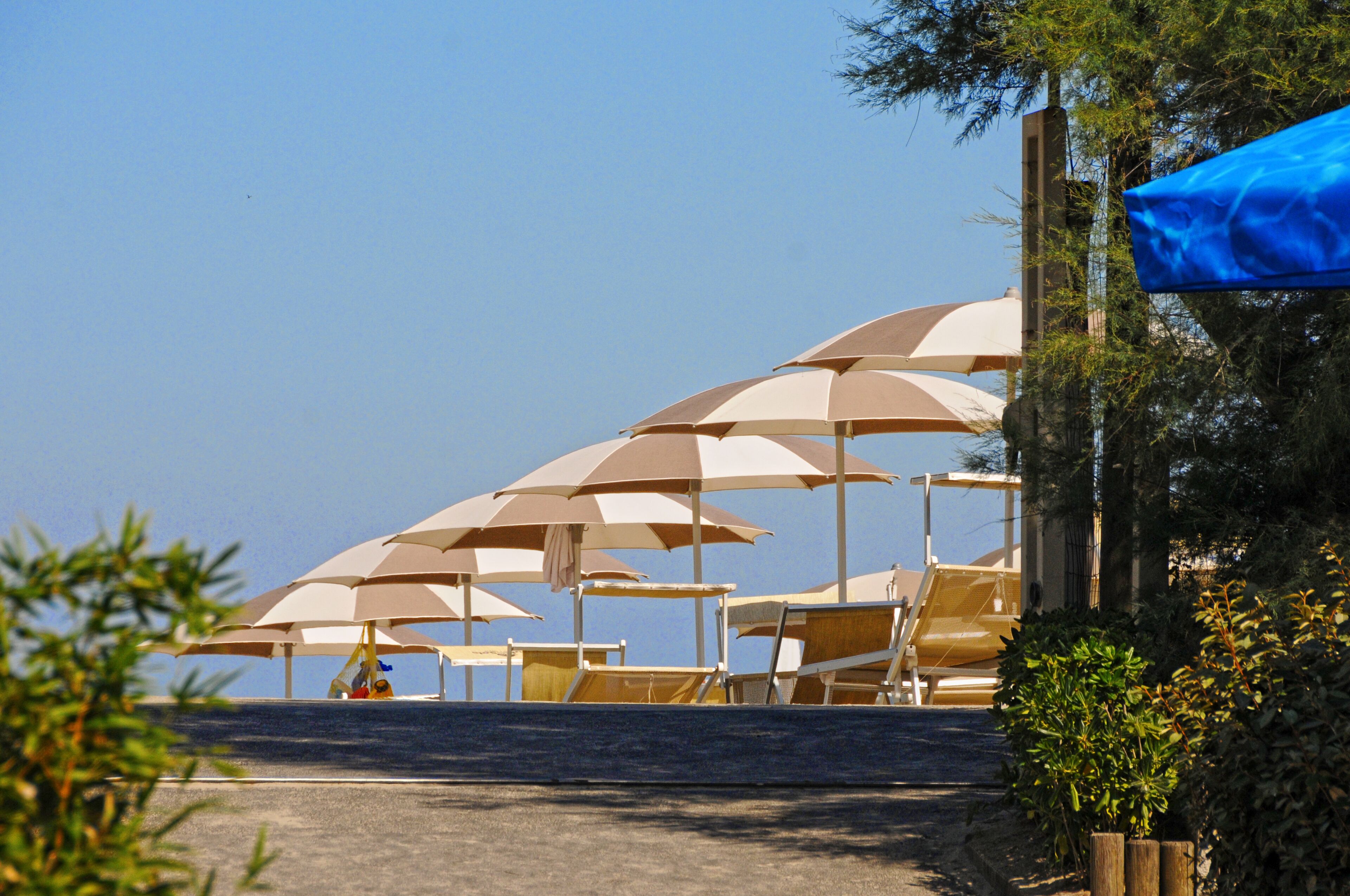 En privat strand, liggestole, parasoller, volleyball