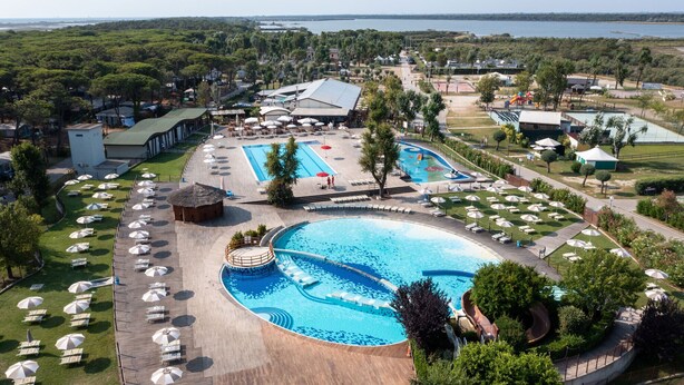 A resort with a large central pool, multiple smaller pools, and a variety of sun loungers and umbrellas. - Club Del Sole Spina Family Collection (Comacchio)