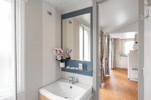 A bathroom with a white sink, a mirror, and a window. - Club Del Sole Spina Family Collection (Comacchio)
