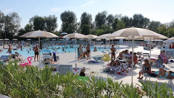 Una piscina al aire libre de temporada, sombrillas