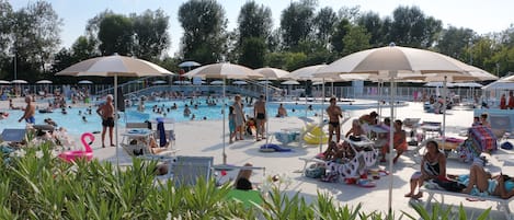 Una piscina al aire libre de temporada, sombrillas