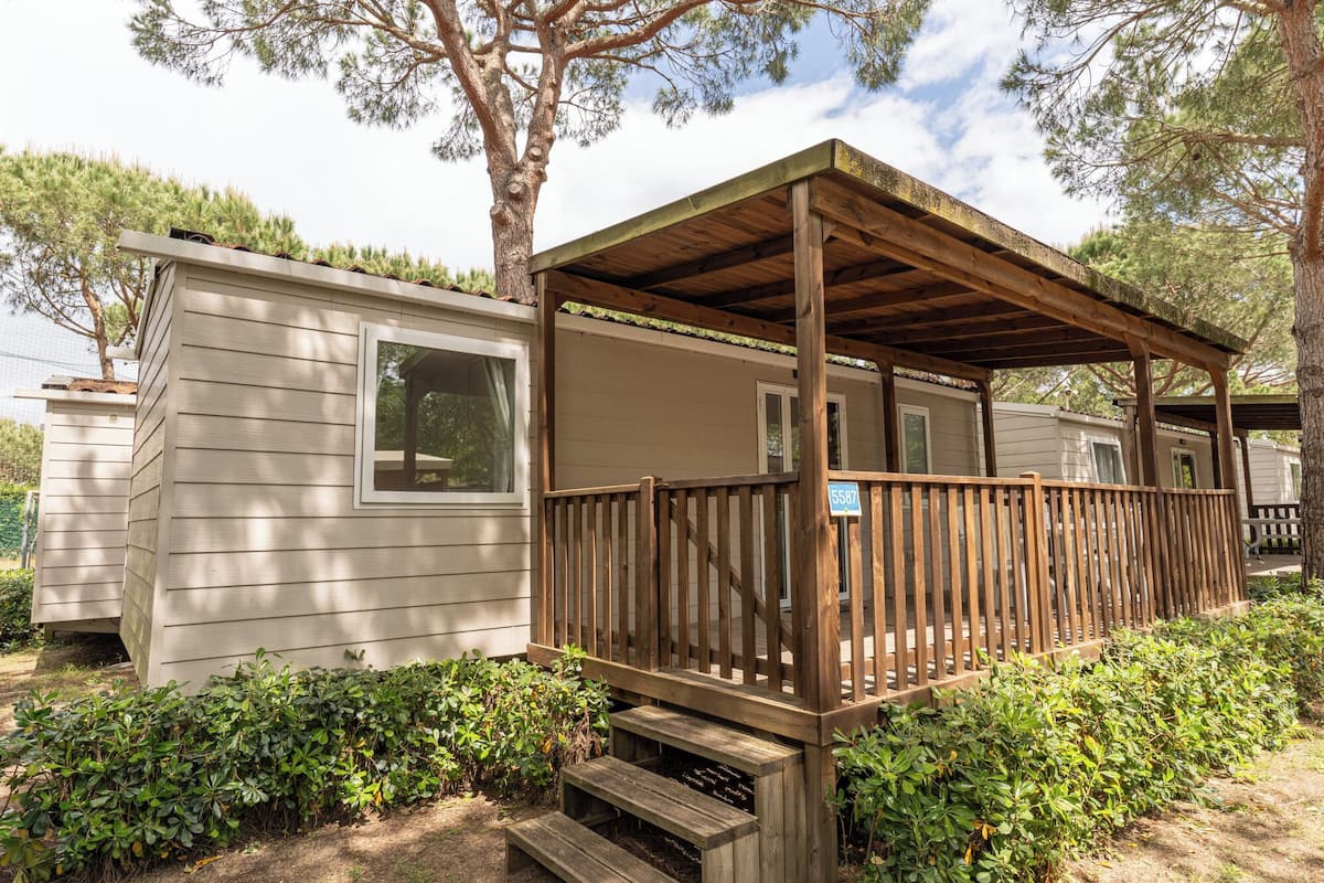 A mobile home with a wooden deck and a covered porch.