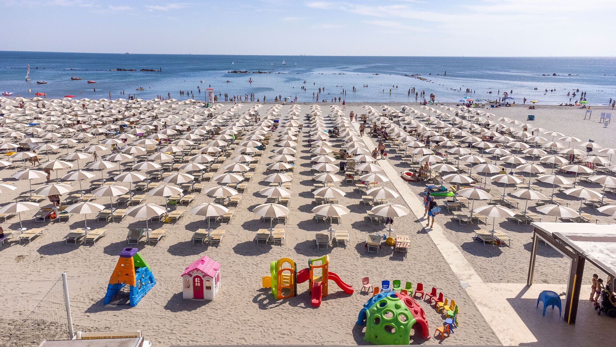 位於海灘上、躺椅、遮陽傘、排球