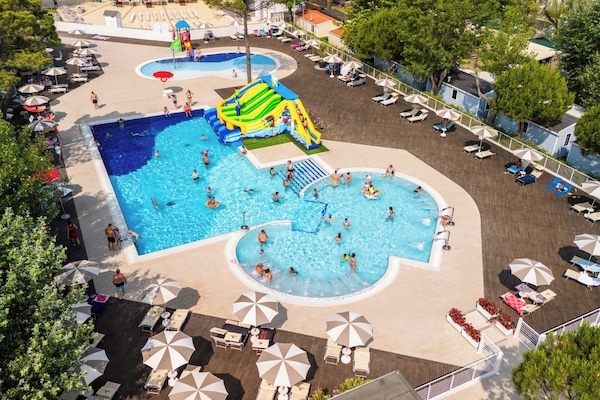 Una piscina al aire libre de temporada, sombrillas