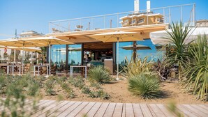 Un ristorante con posti a sedere all'aperto, una piscina e vista sull'oceano.