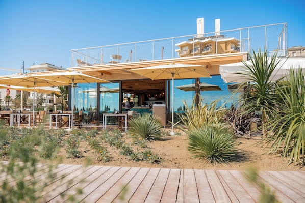 Ein Restaurant mit Außenbereich, einem Pool und Meerblick.